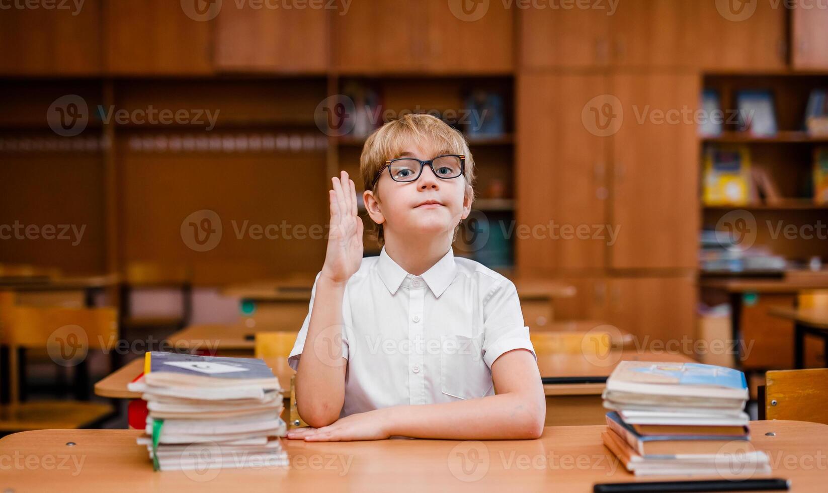 Student boy reading book and looking very surprised in the school classroom photo