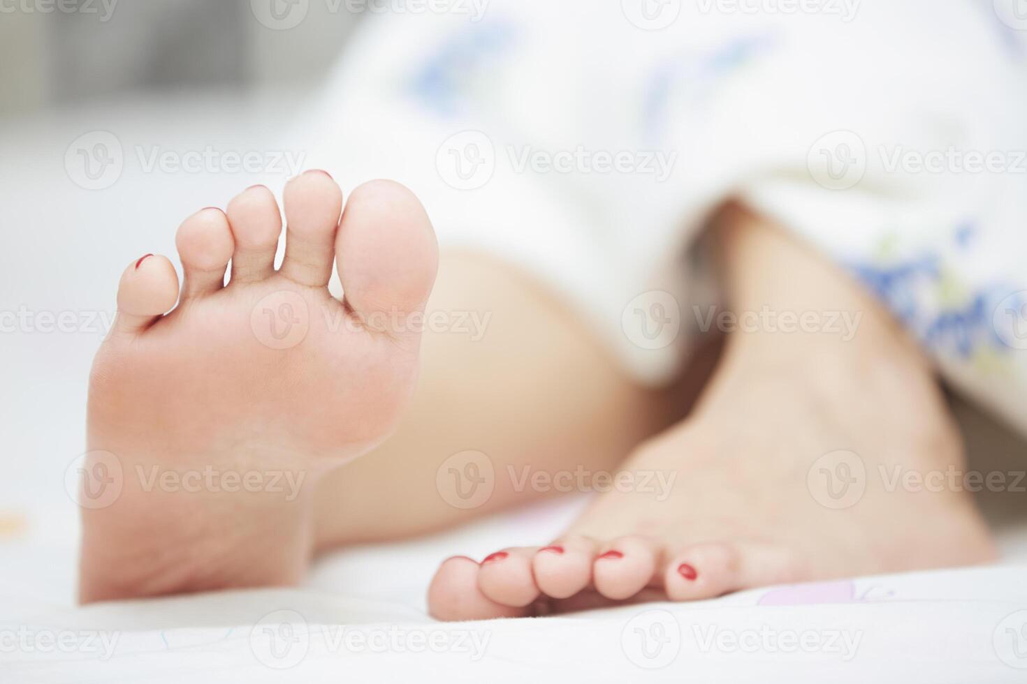 Feet of sleeping woman in a bed photo