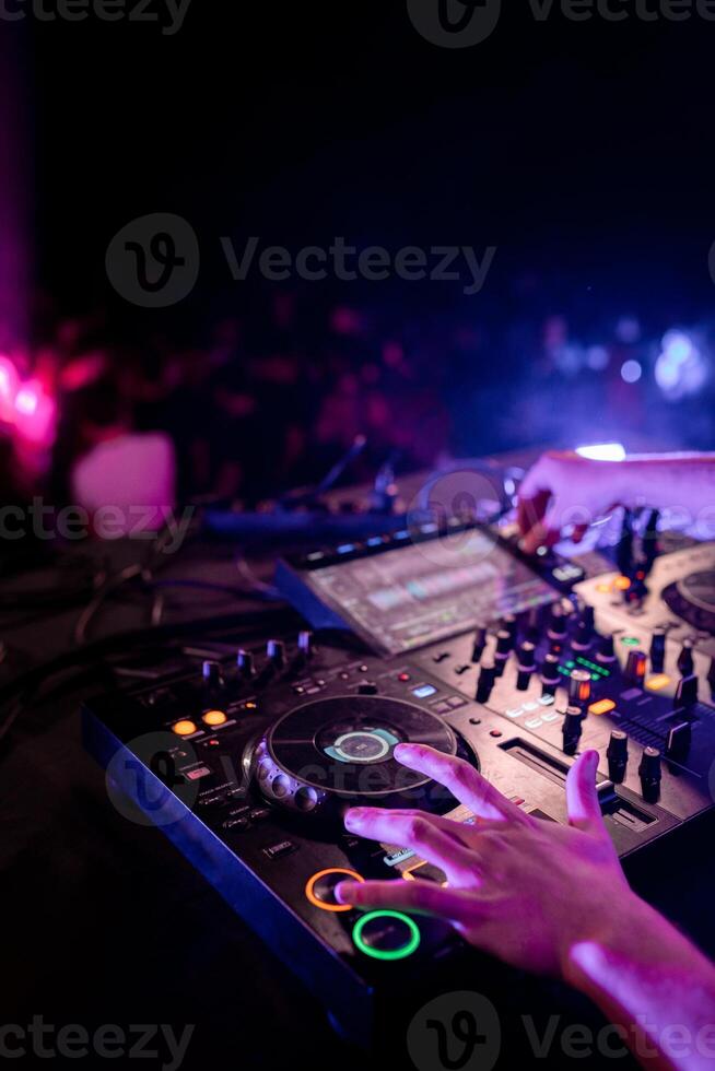 Hands of DJ performing in stage in a disco photo