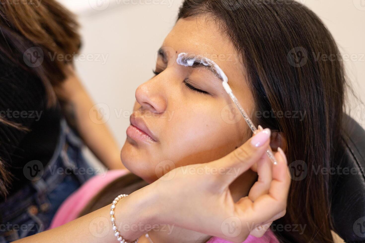 Beautician making eyebrow design and lamination procedures. Method photo