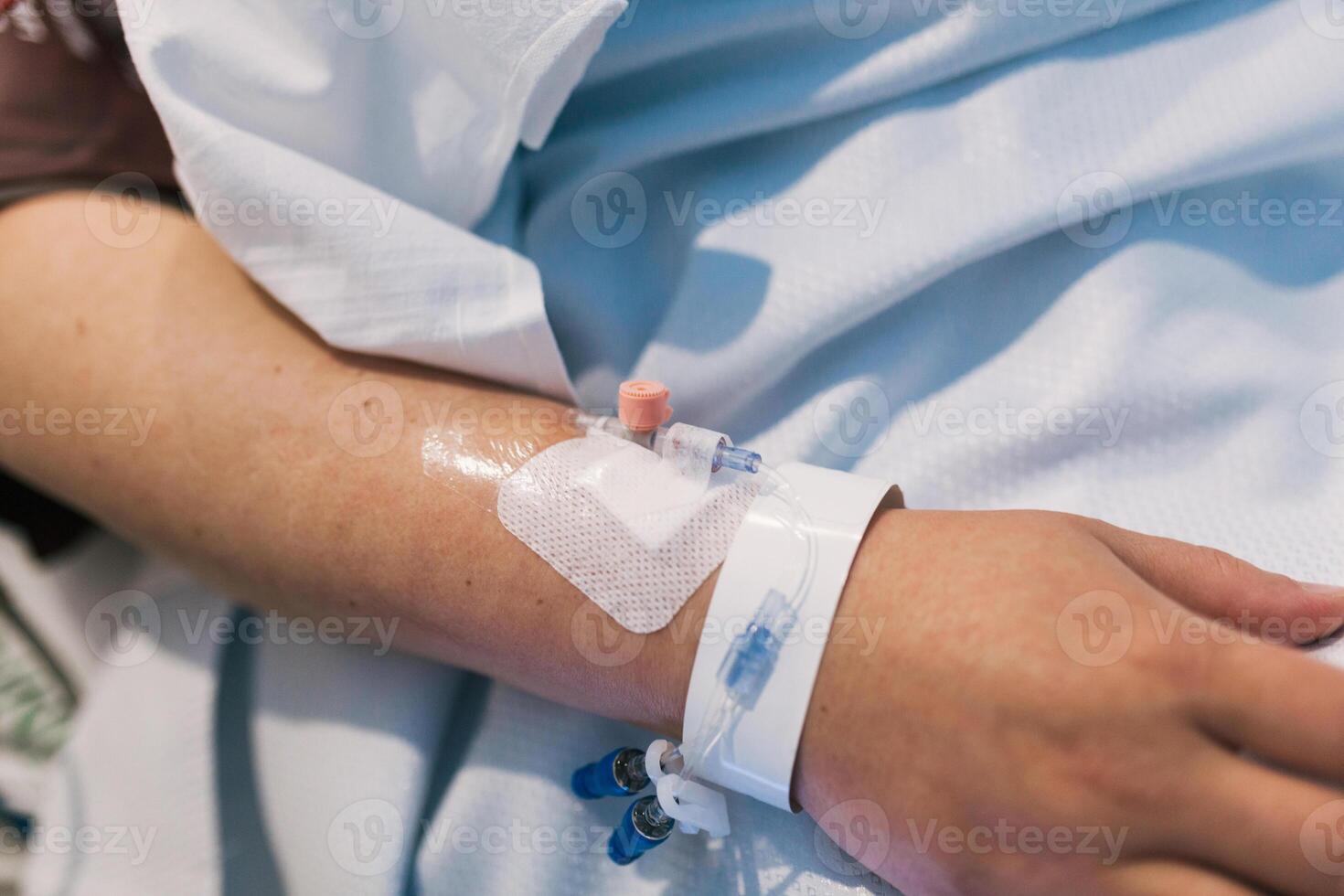 Close up view of the hand of a patient in a hospital bed. photo