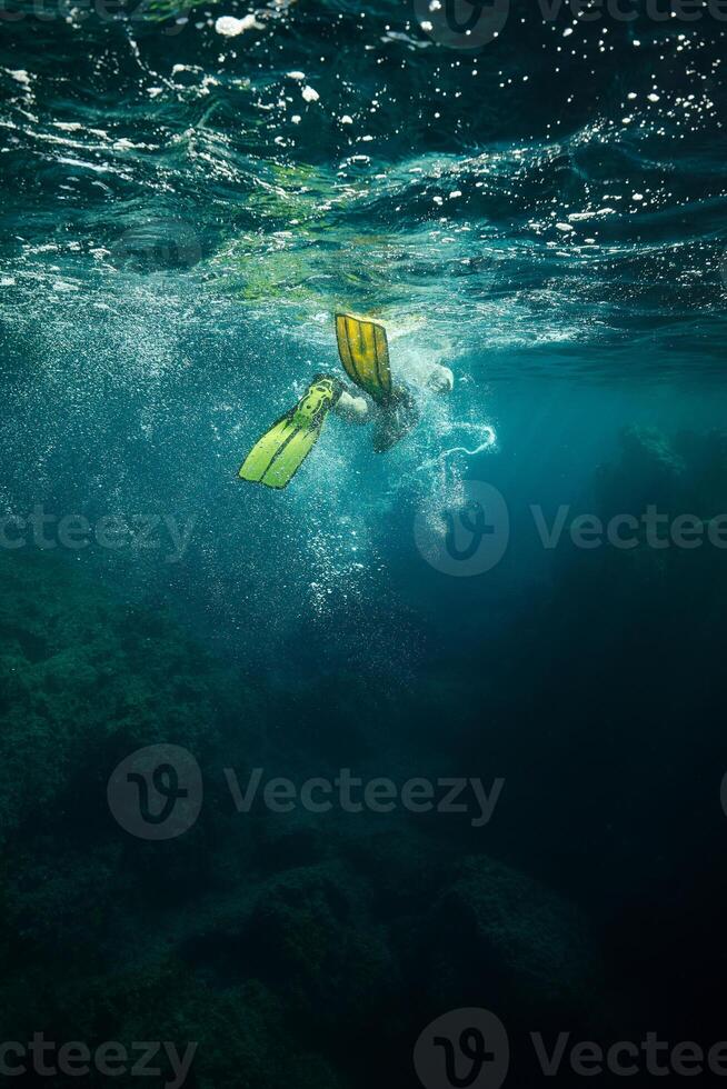 Diver swimming under water in flippers photo