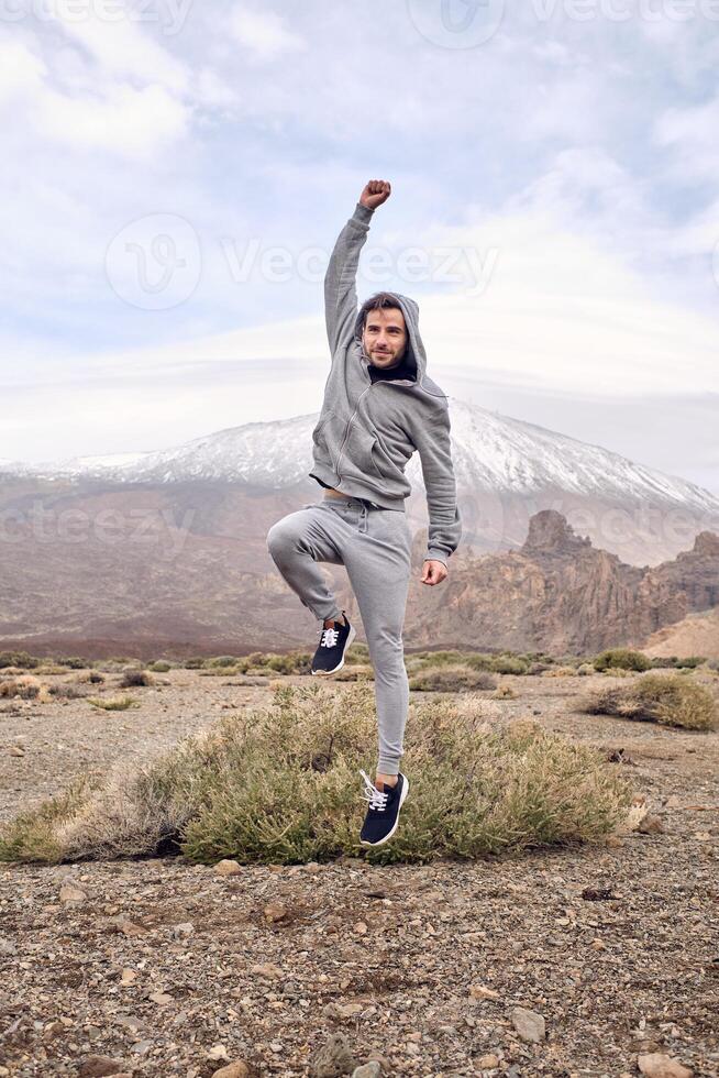 Happy man jumping with fist up while celebrating triumph photo
