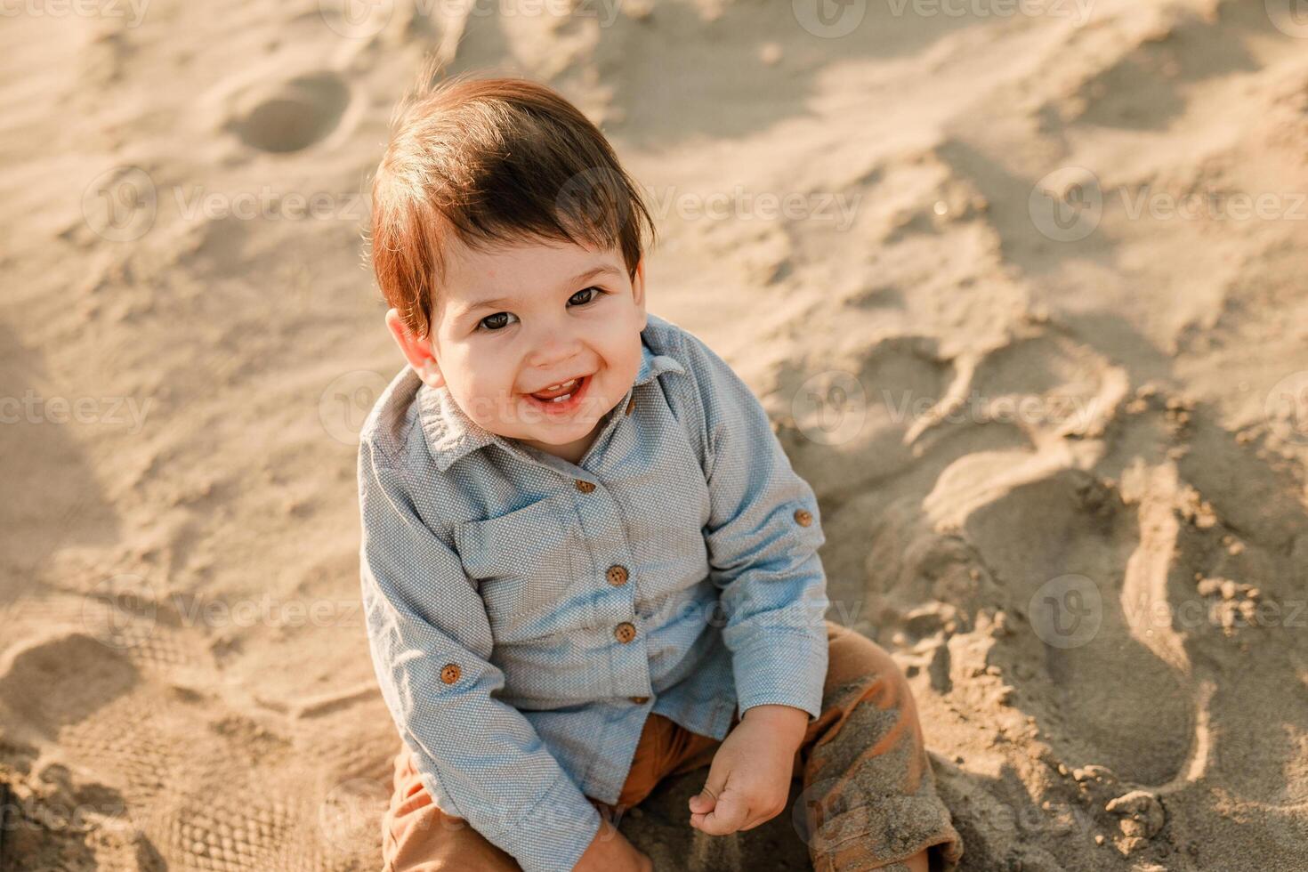 Infant cute boy exploring the sandy river shore in spring. photo