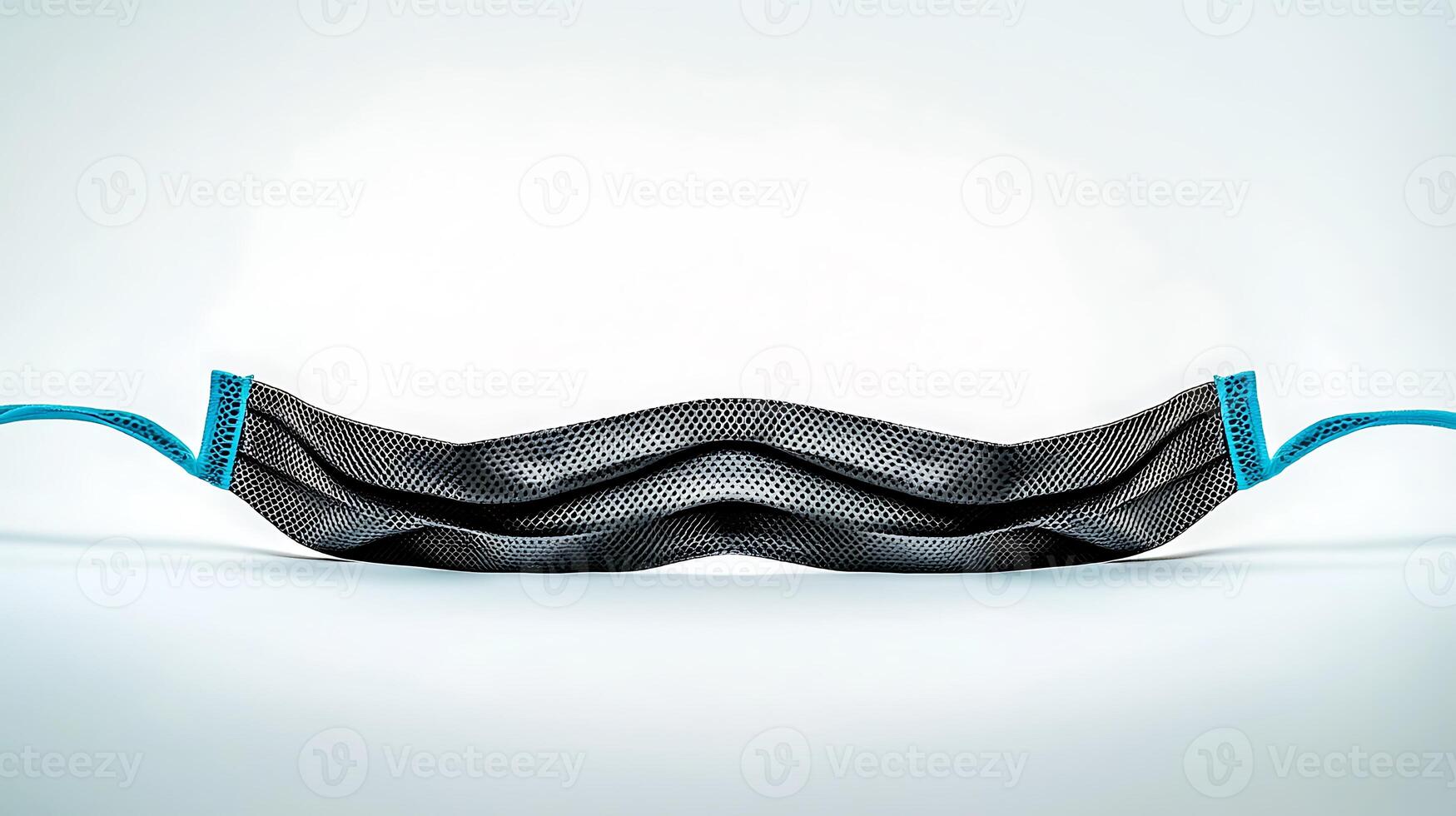Close-up of a black and blue textured face mask lying flat on a neutral background photo