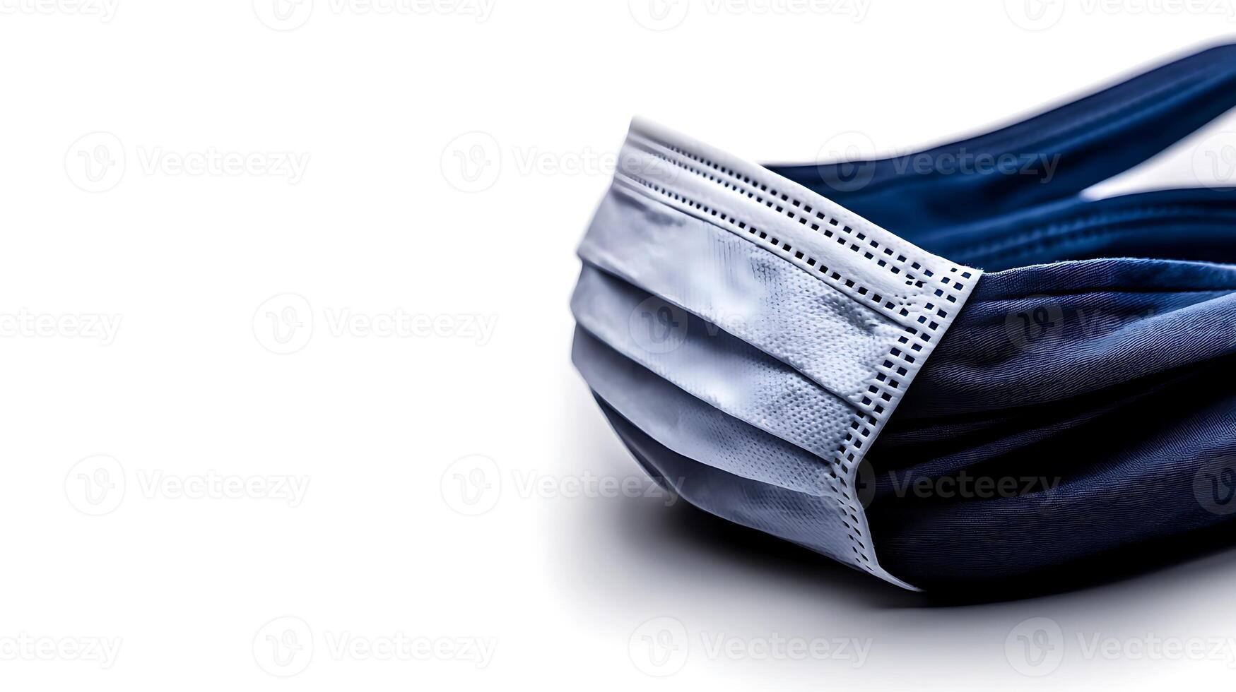 Close-up of a folded medical mask resting on a smooth surface, highlighting its texture and design photo