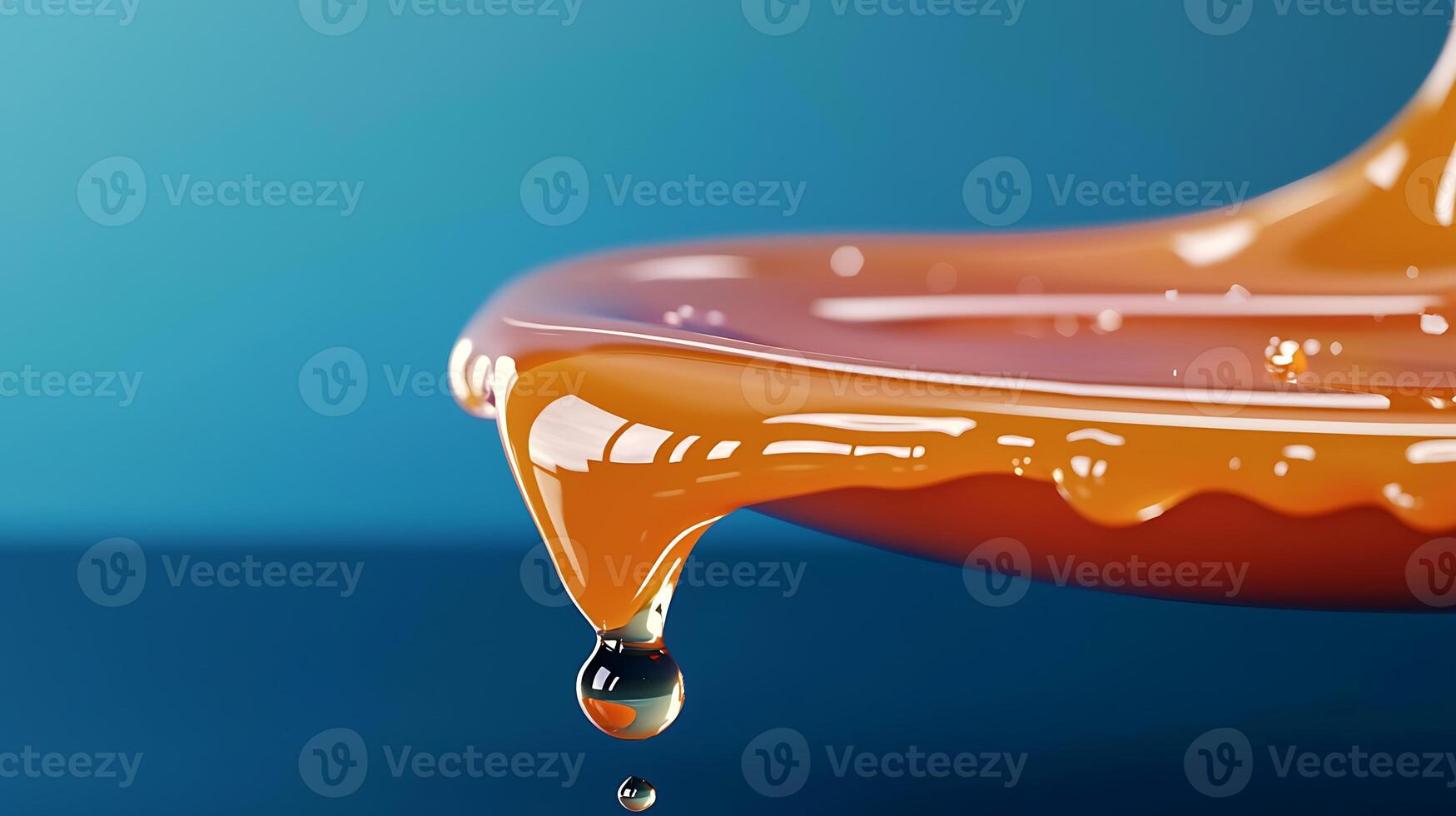 Close-up of orange syrup dripping from a dish against a blue background, showcasing texture and flow photo