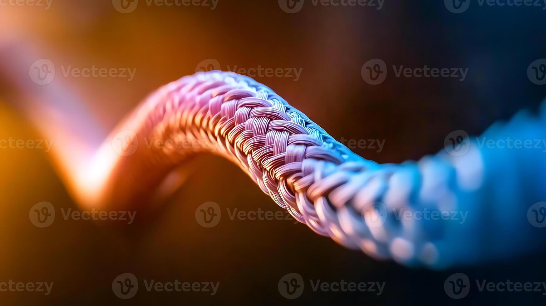 Close-up view of a colorful braided rope illuminated by soft light against a dark background photo