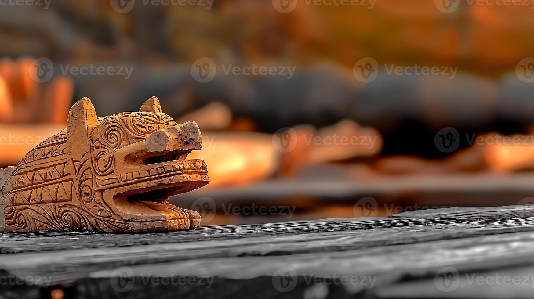 Intricately carved wooden animal figure resting on a weathered log, surrounded by natural scenery photo