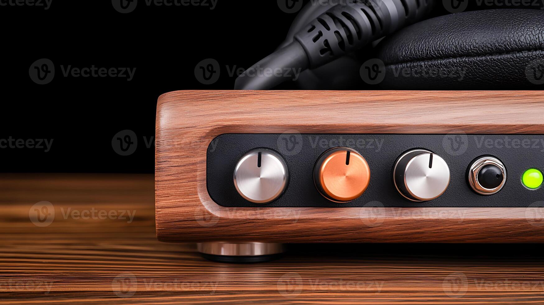 Close-up of a stylish audio amplifier showcasing knobs and headphone jack on a wooden surface photo