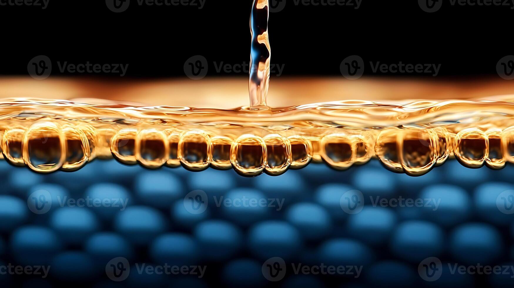Close-up of golden liquid with bubbles, flowing over a textured blue background, creating a dynamic visual photo