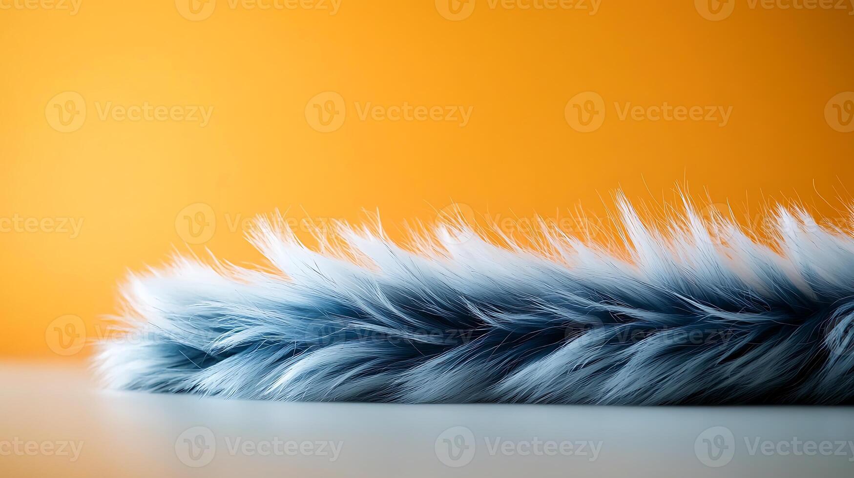 Soft blue fur lying on a smooth surface against a vibrant orange background, creating contrast photo