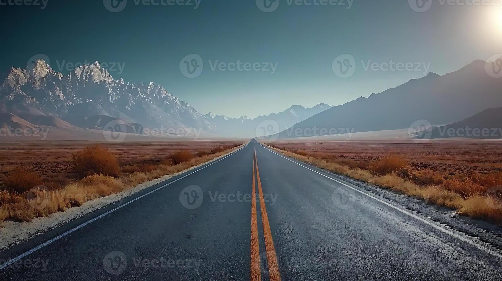 Serene highway stretching towards majestic mountains under a clear sky at sunset photo