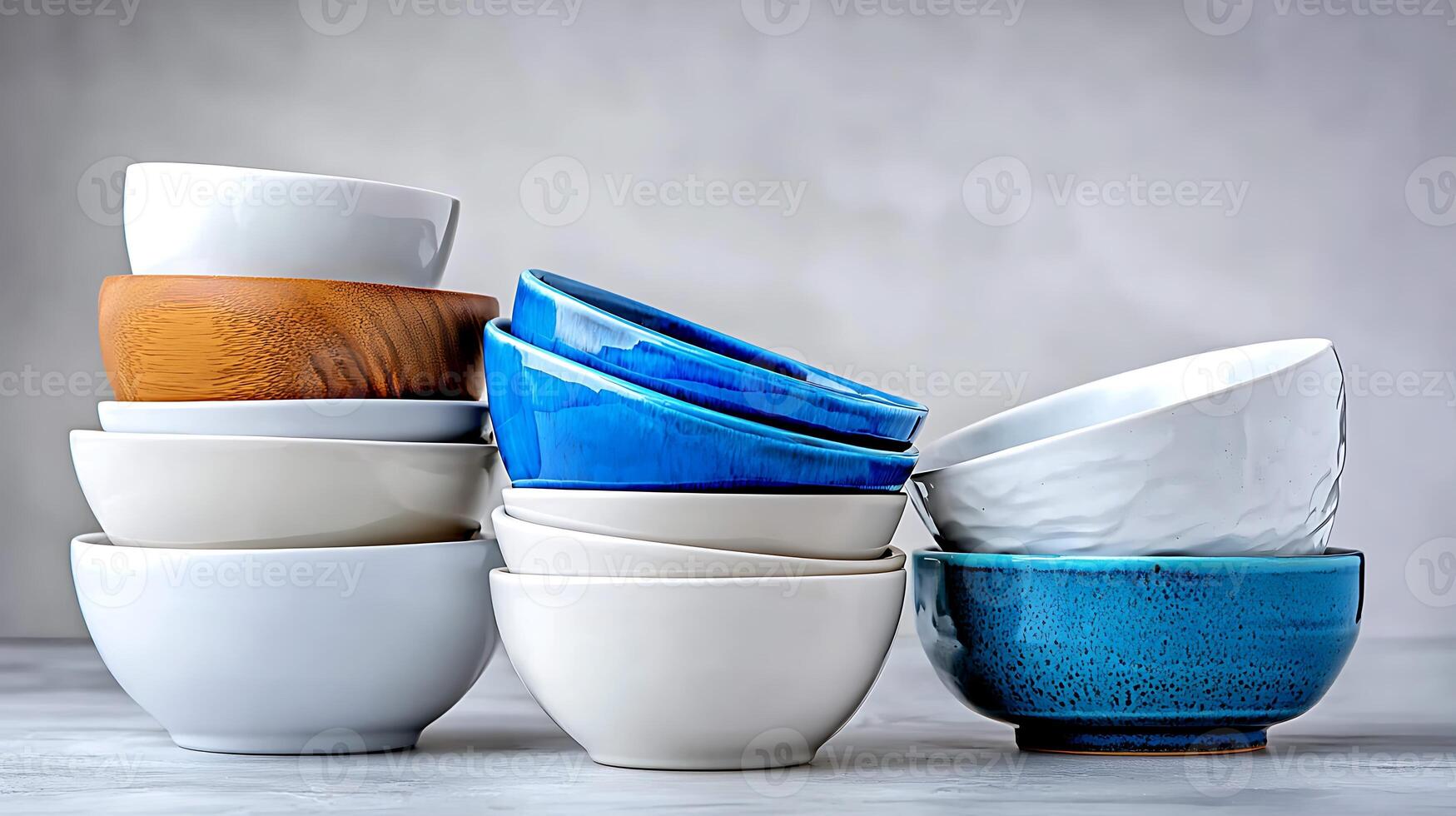 Stacked bowls of various colors and materials arranged artistically on a neutral background photo