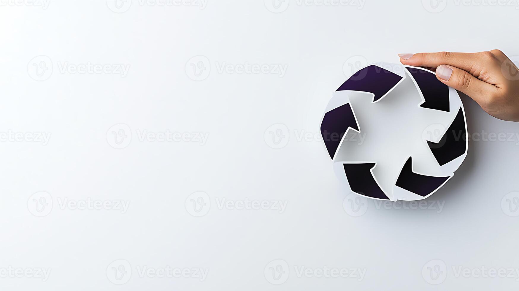 Hand holding a recycling symbol on a plain background, emphasizing sustainability and eco-friendliness photo