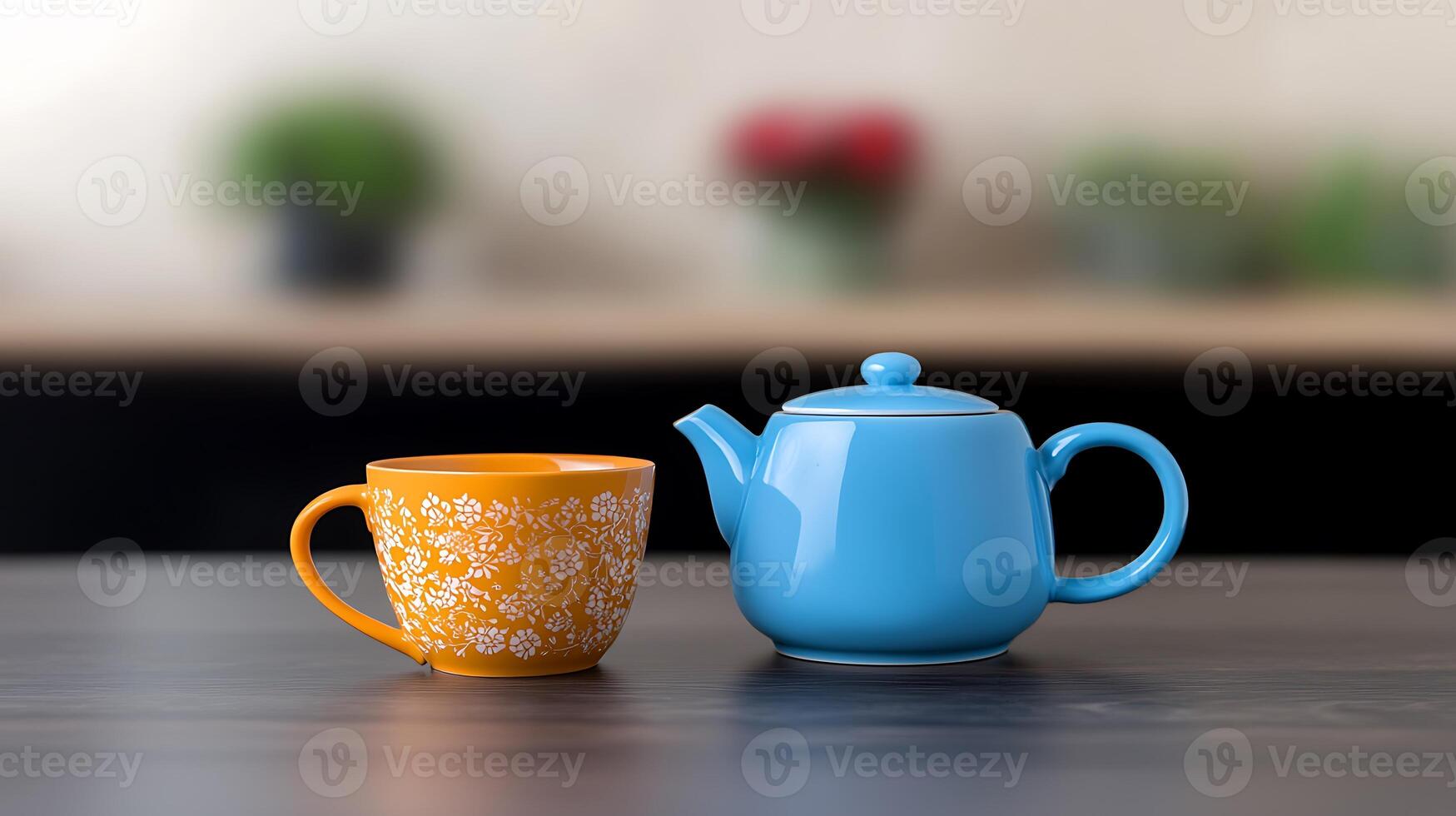 Colorful tea set featuring a blue teapot and orange floral cup on a wooden table with blurred background photo