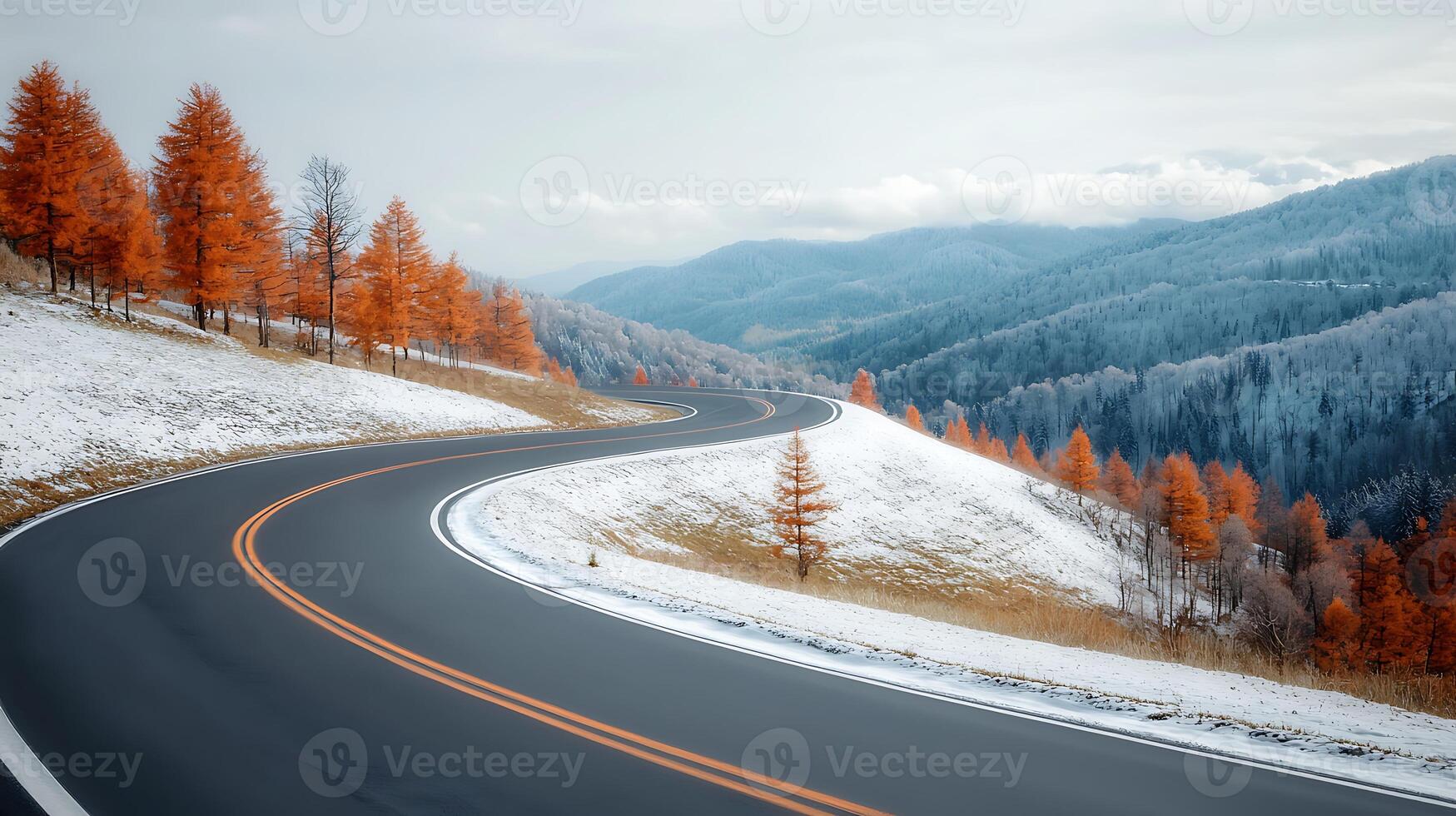 Serene winding road through autumn trees and snow-capped mountains under a cloudy sky photo