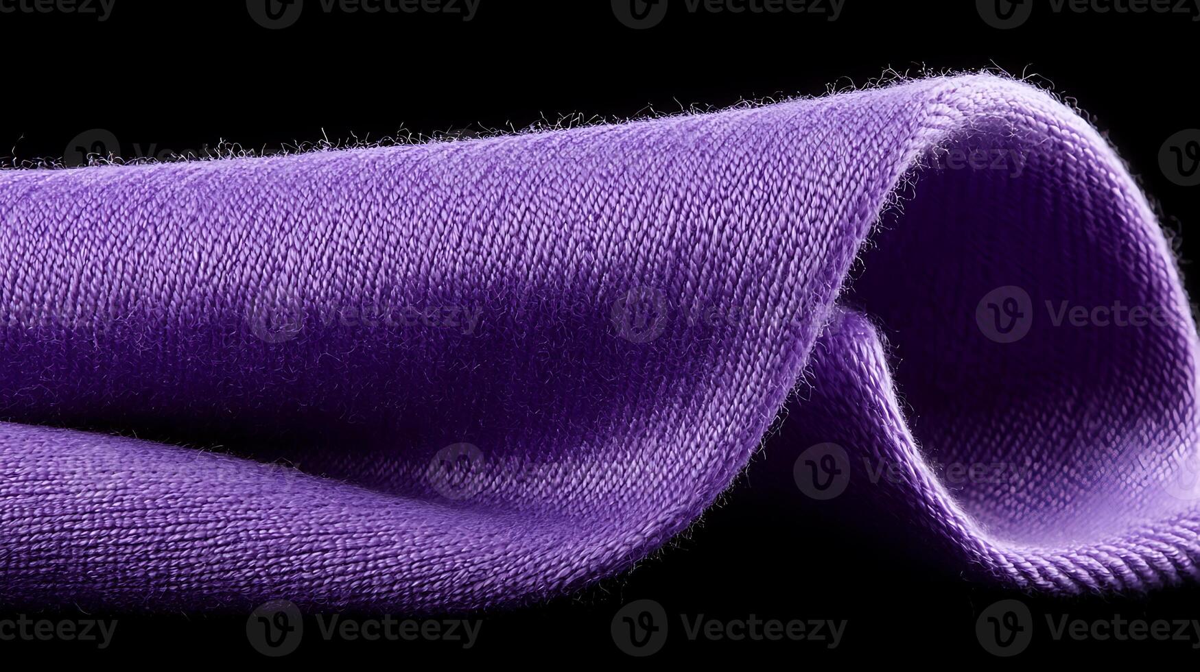 Close-up of a soft, flowing purple fabric draped elegantly against a dark background photo