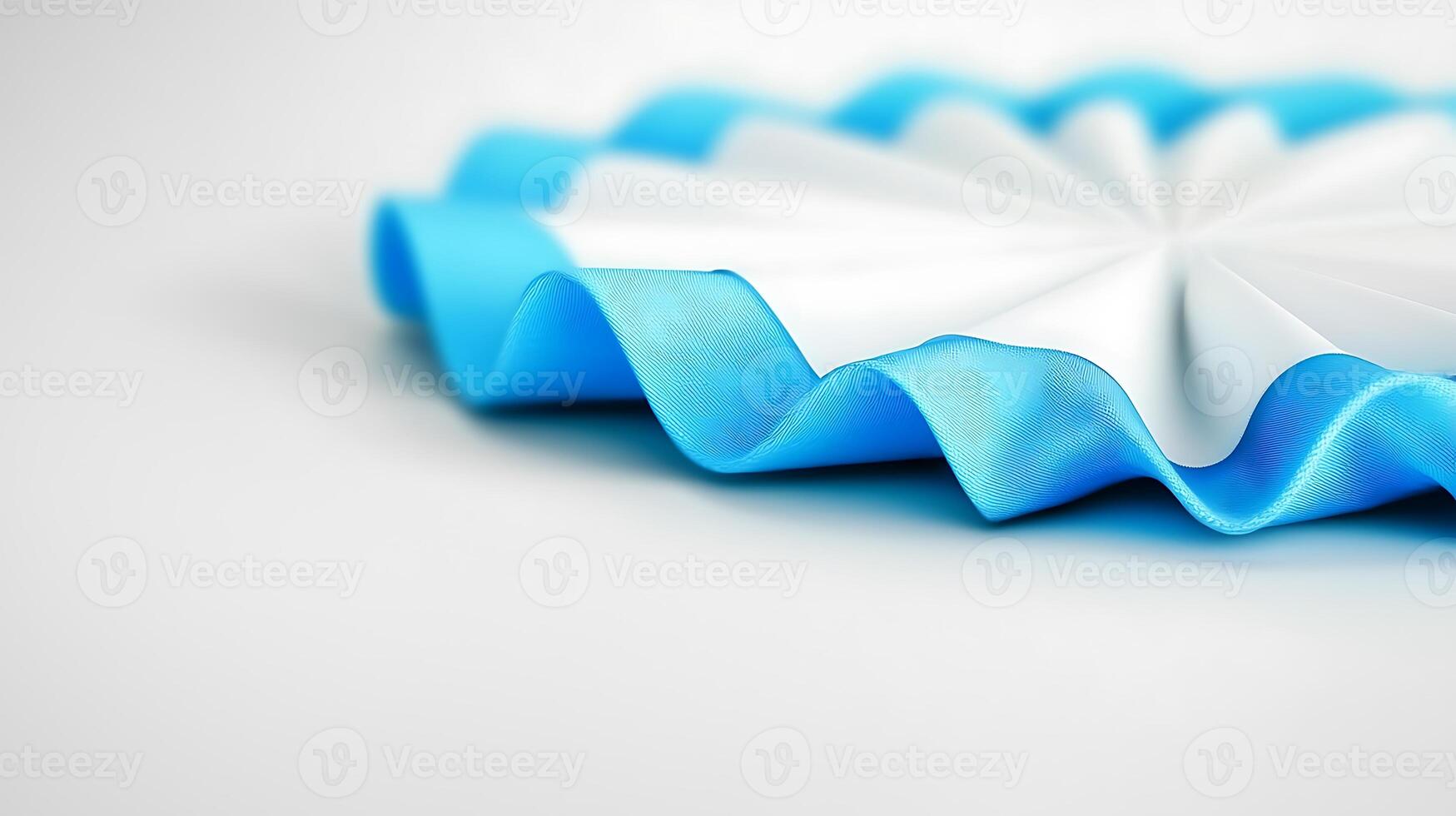 Close-up view of a decorative blue and white ribbon rosette on a smooth surface, highlighting its texture photo