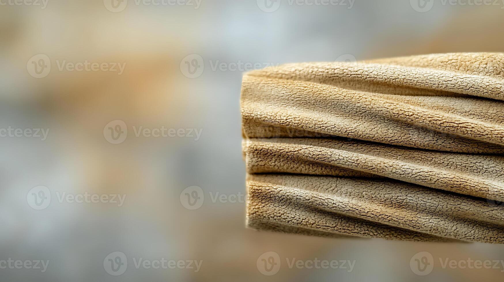 Close-up of textured fabric with soft folds against a blurred warm background photo