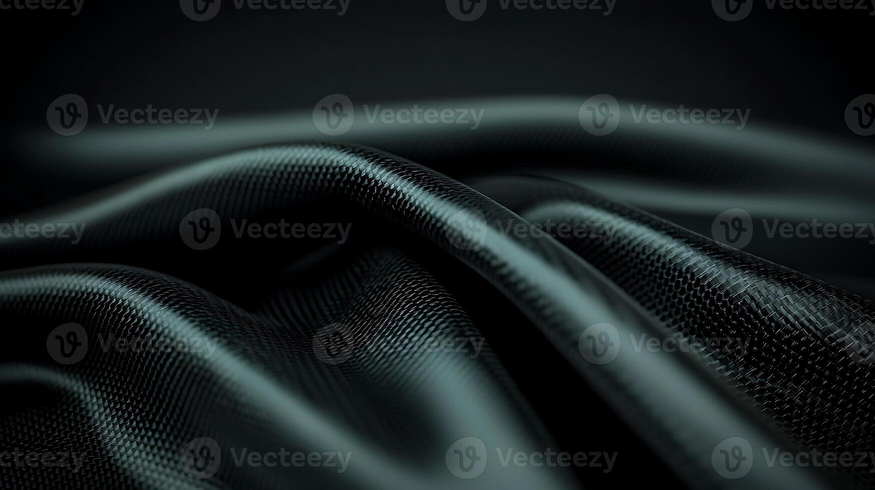 Close-up of smooth, flowing black fabric with subtle texture against a dark background photo