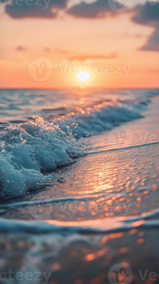 Soft ocean waves washing ashore at sunset with golden light reflecting on the water photo