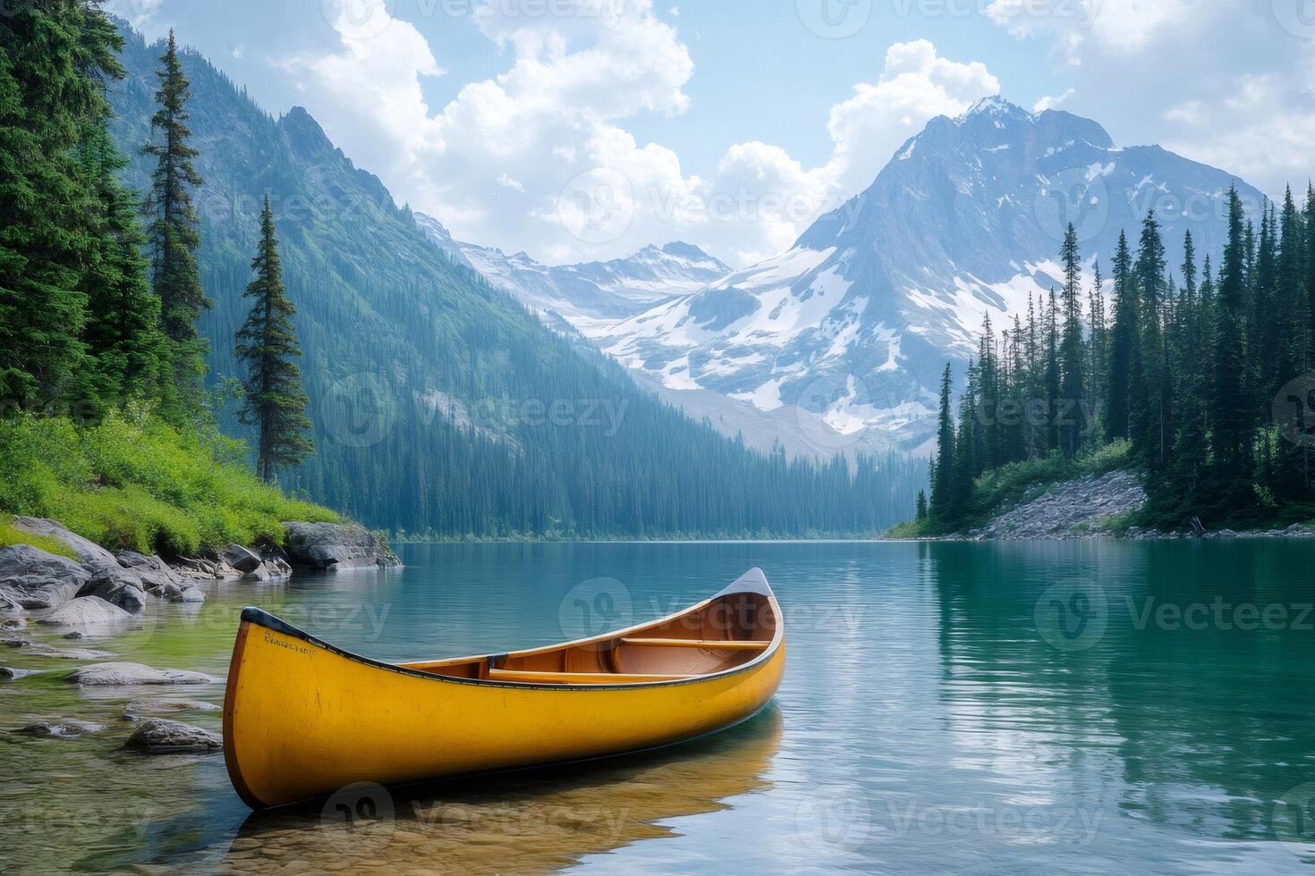 Yellow canoe resting on a pristine mountain lake in british columbia photo