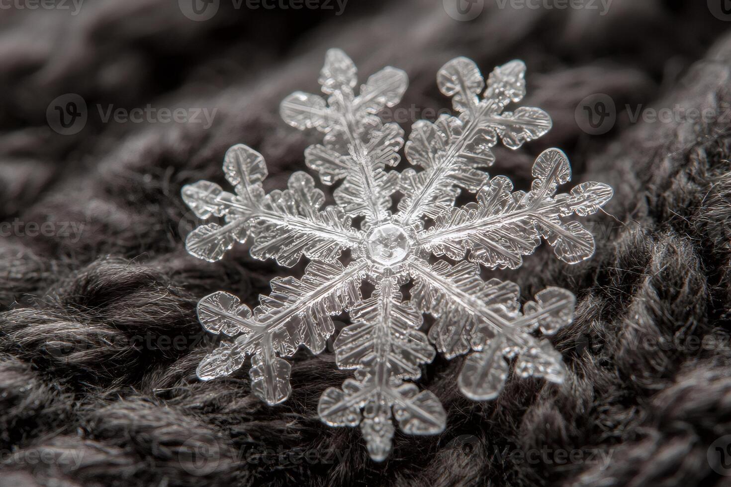 Intricate snowflake crystal lying on soft dark woolen surface photo