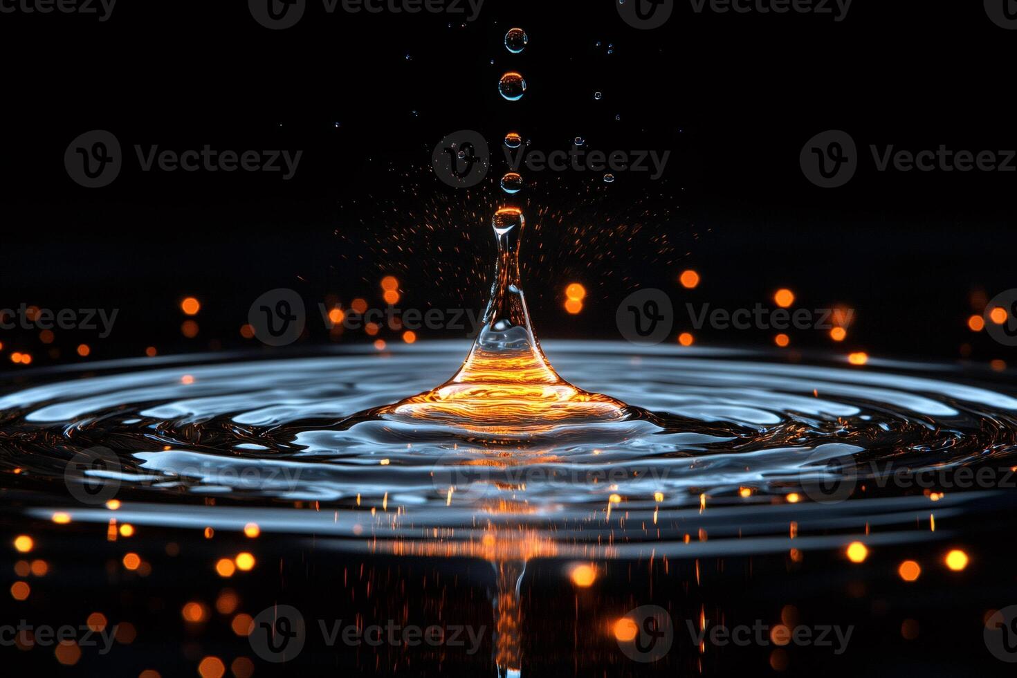Water droplet splashing creating concentric ripples with orange bokeh lights photo