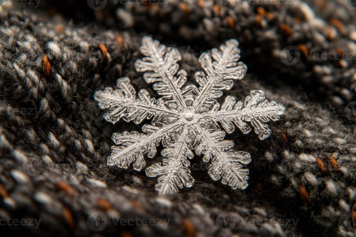 Real snowflake resting on knitted wool showing intricate structure photo