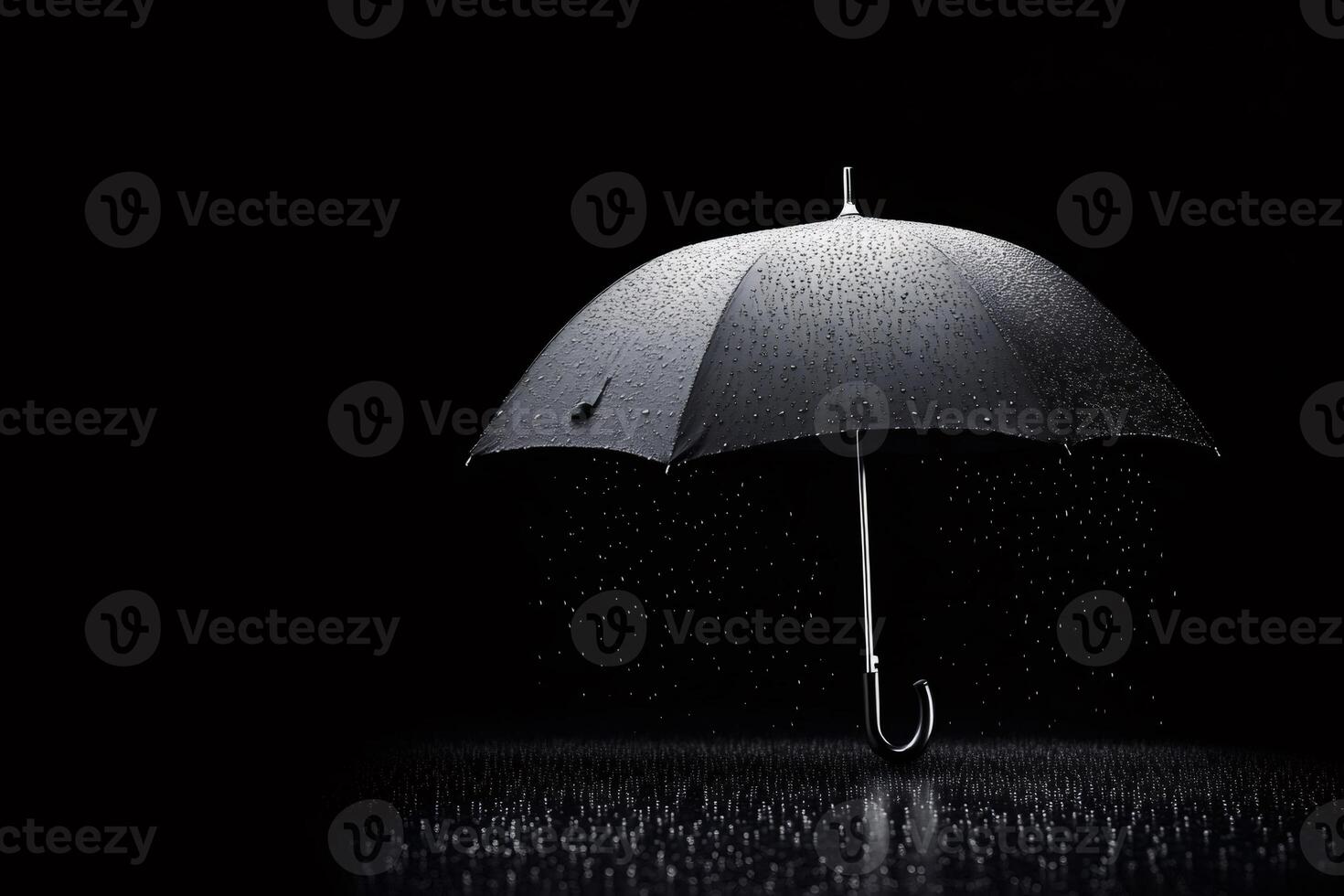 Black umbrella protecting from rain on dark background.. photo