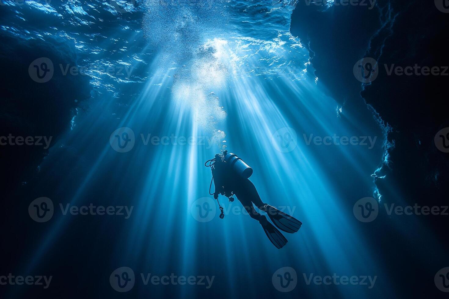 Scuba diver exploring underwater cave with sunlight beams piercing through water surface photo