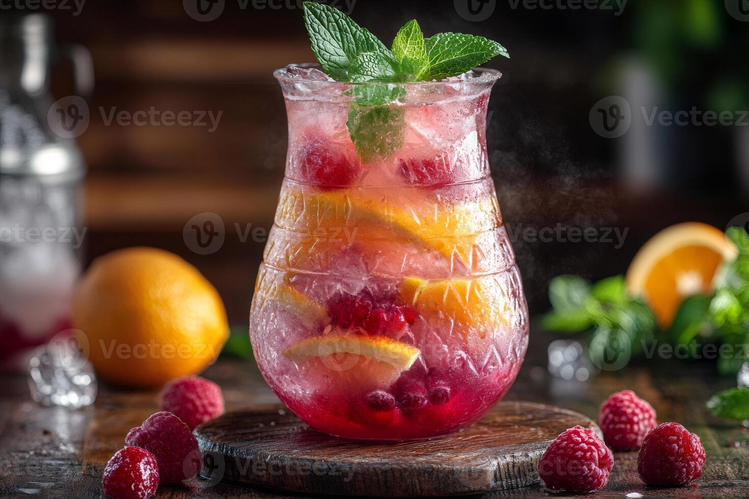 Refreshing raspberry and orange lemonade with ice and mint in a glass pitcher photo