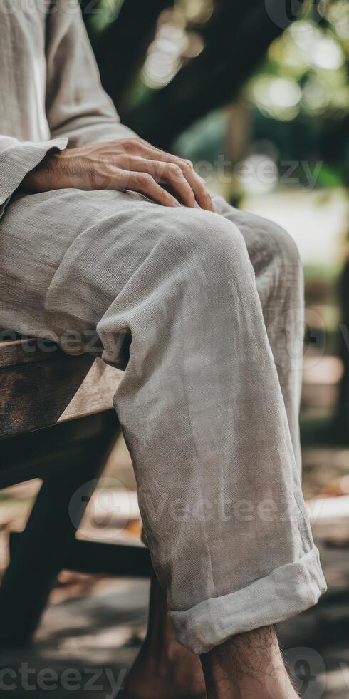 A man sitting on a bench with his legs crossed photo