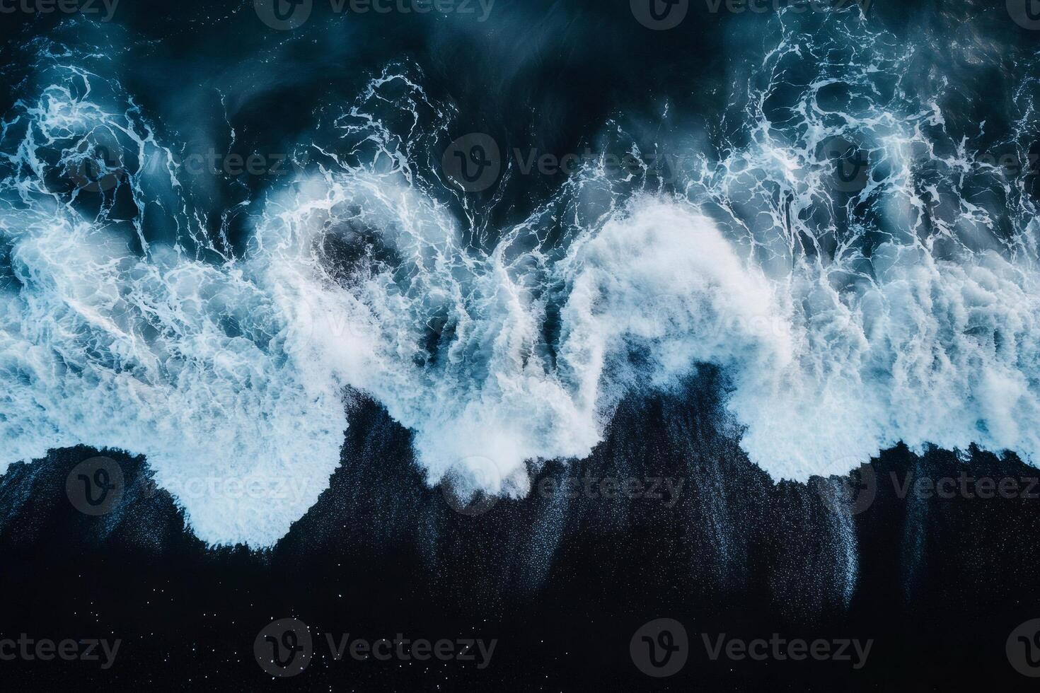 Ocean waves crashing on black sand beach, creating stunning contrast photo