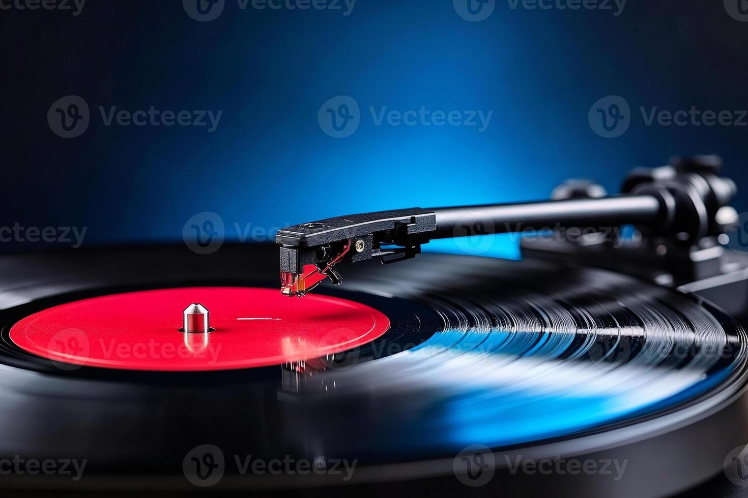 Vinyl record player playing music with red label on blue background photo
