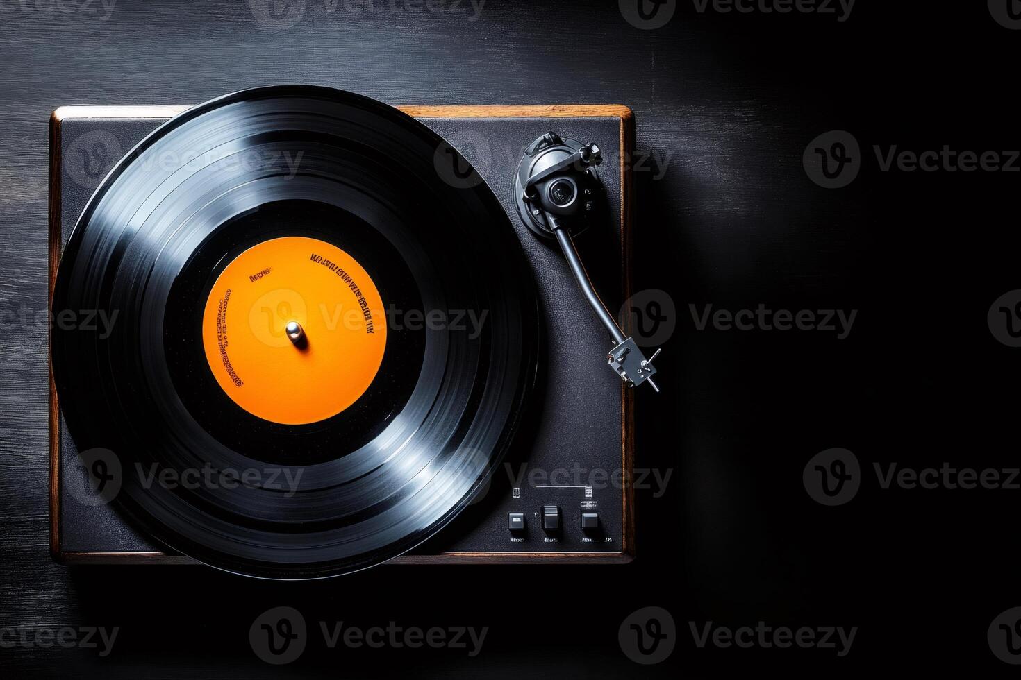 Vinyl record playing on vintage turntable with orange label on dark background photo
