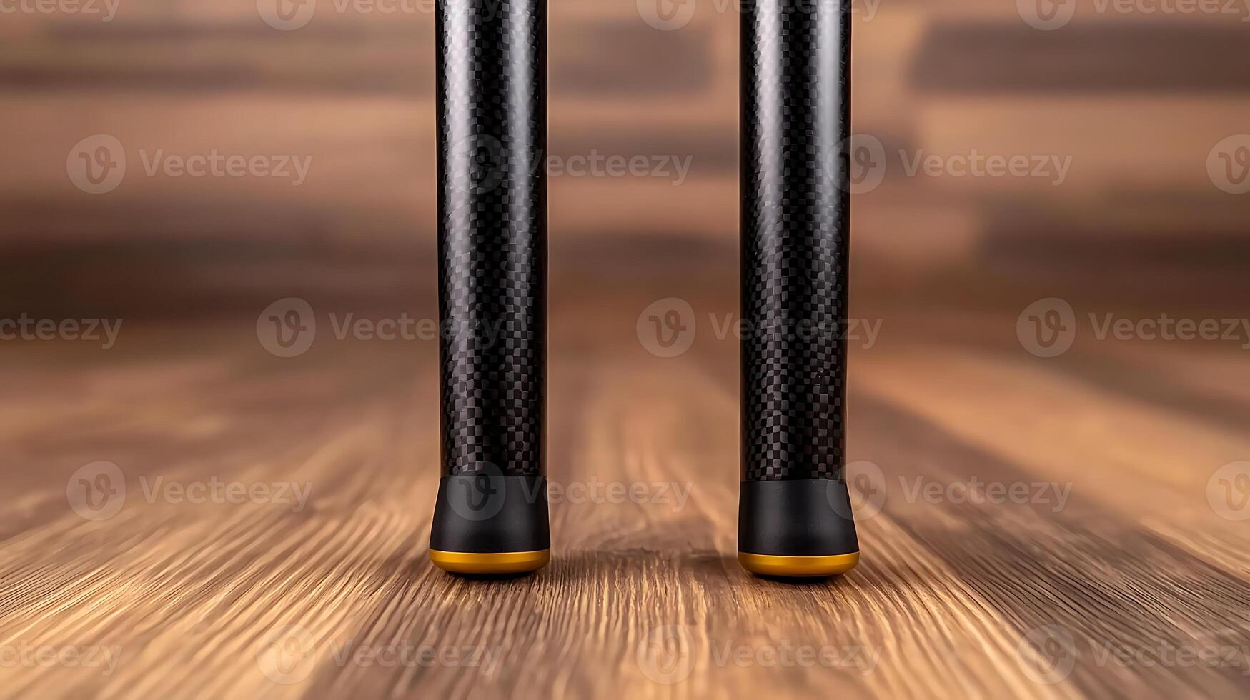 Close-up view of two sleek, modern tripod legs on a wooden floor, showcasing design and texture photo