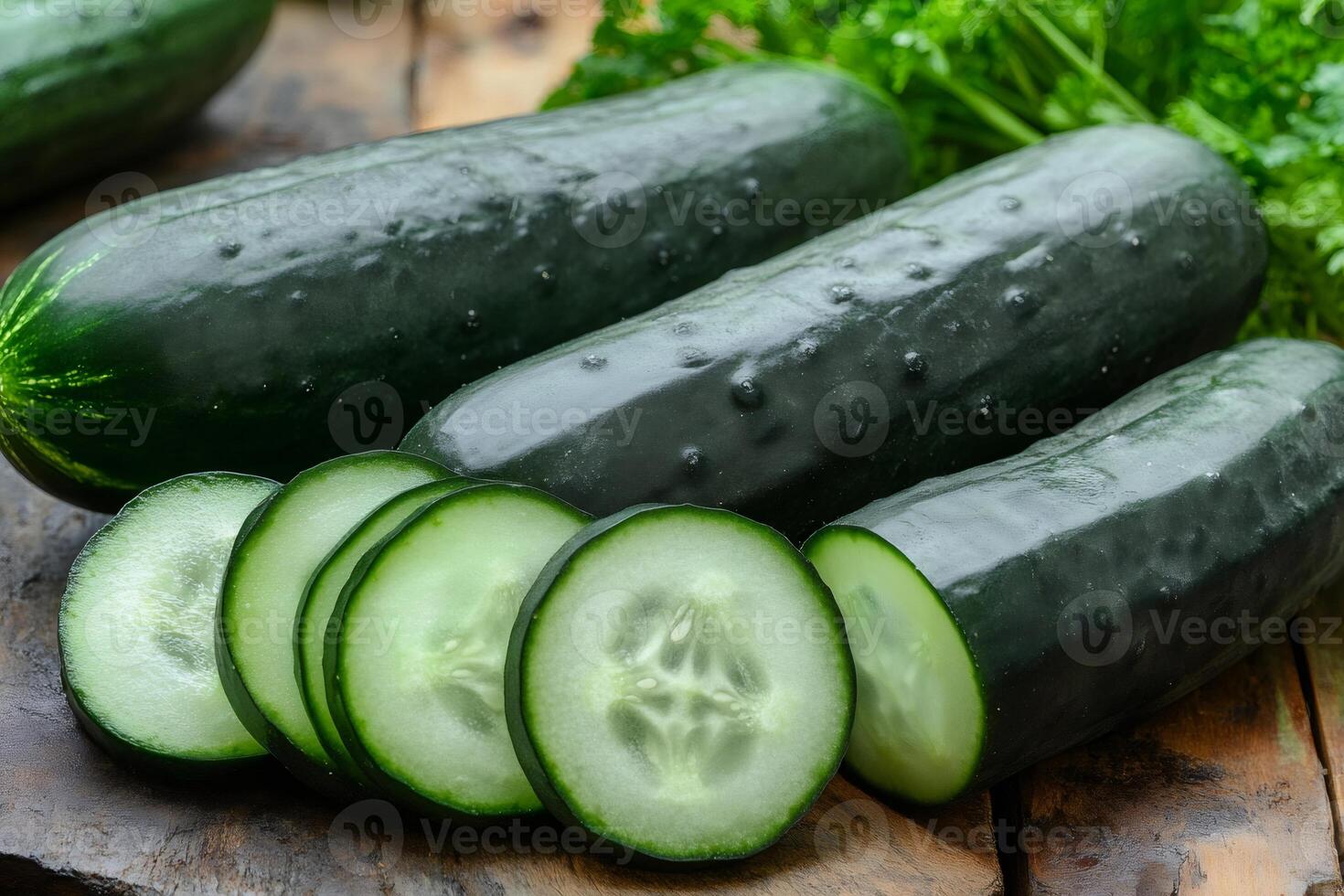 Fresh cucumbers and slices resting on rustic wooden table photo