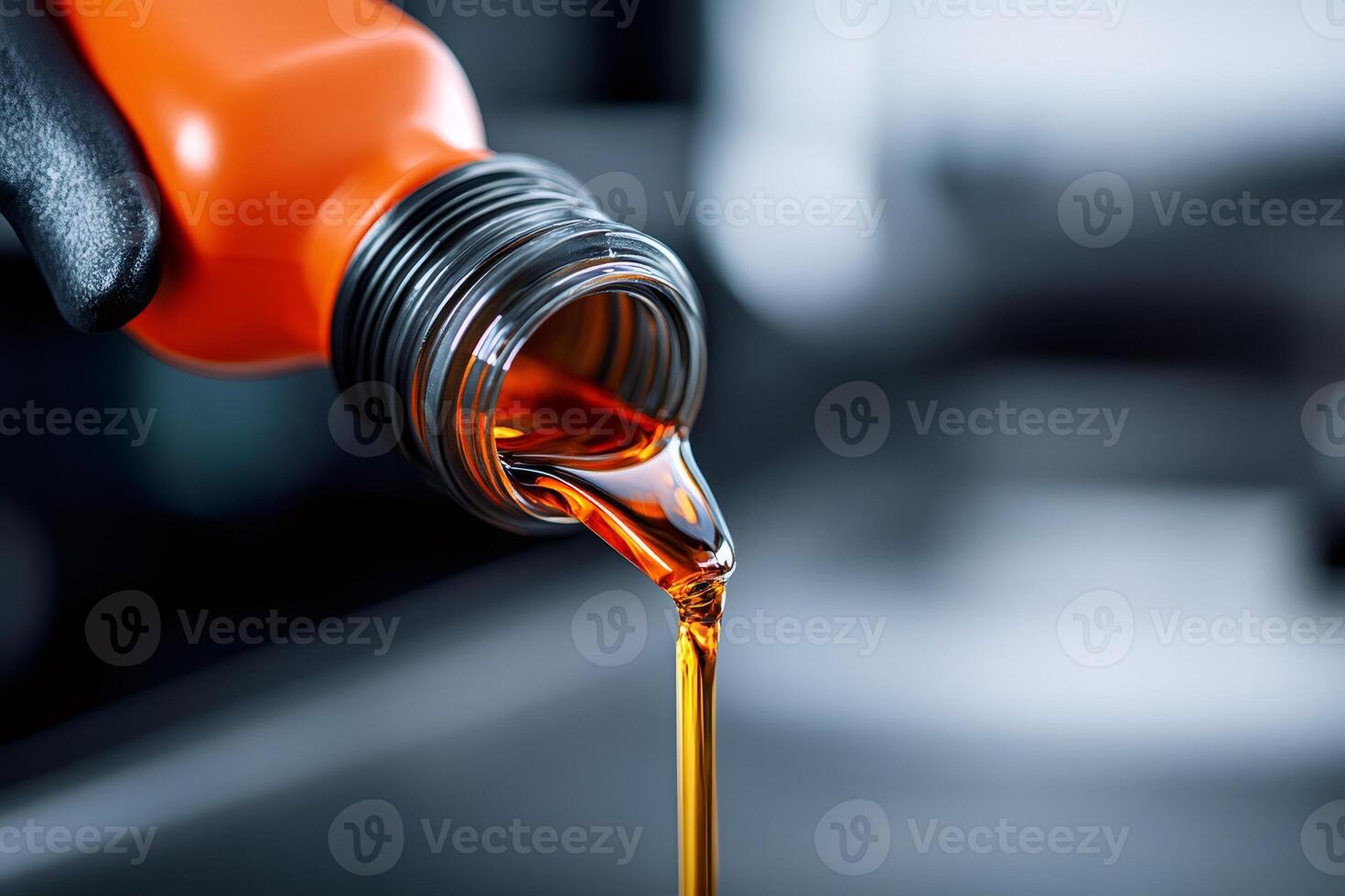 Mechanic pouring new fresh engine oil from orange bottle photo