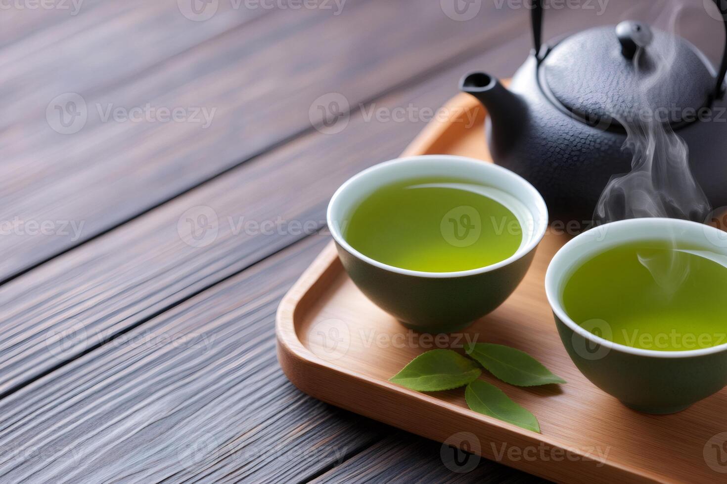 Steaming green tea and teapot on wooden tray, traditional asian beverage photo