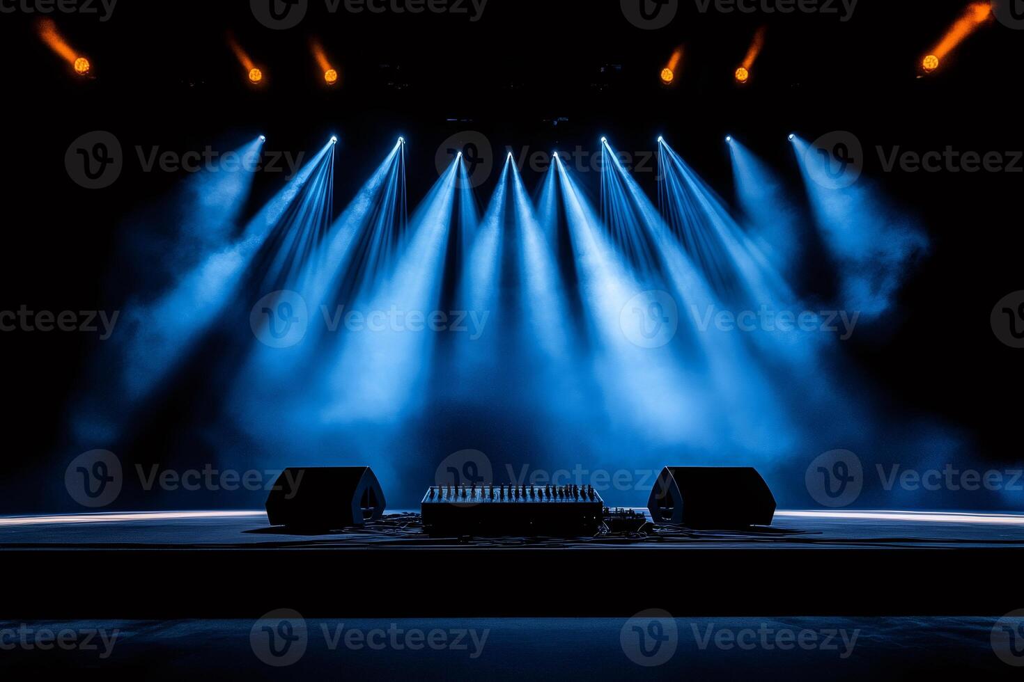 Empty stage illuminated by blue spotlights with mixing console and speakers waiting for the show photo
