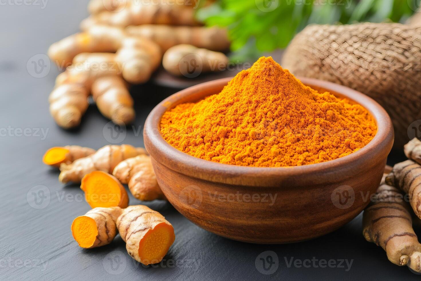 Turmeric powder in wooden bowl with fresh turmeric root photo