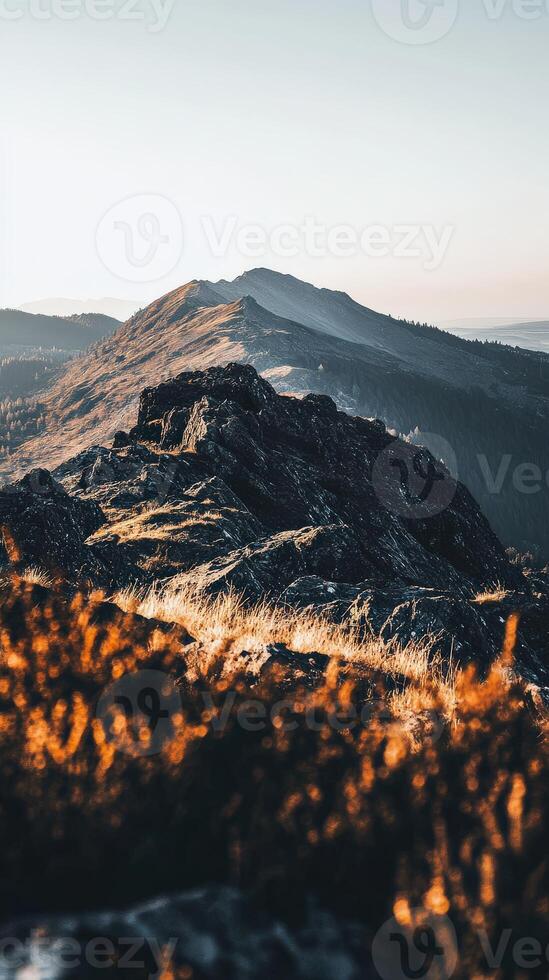 A mountain with grass and rocks on top photo