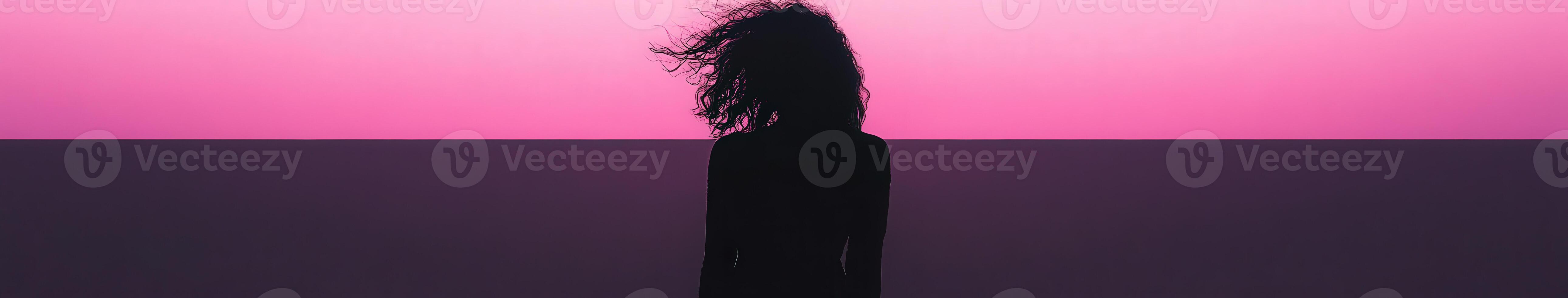 A black woman standing in front of a pink background photo