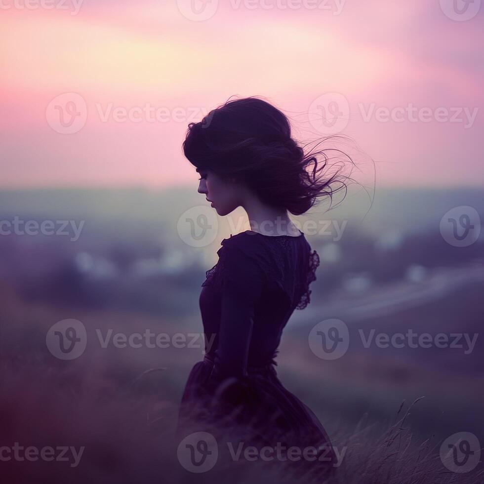 A woman in a black dress standing in a field photo