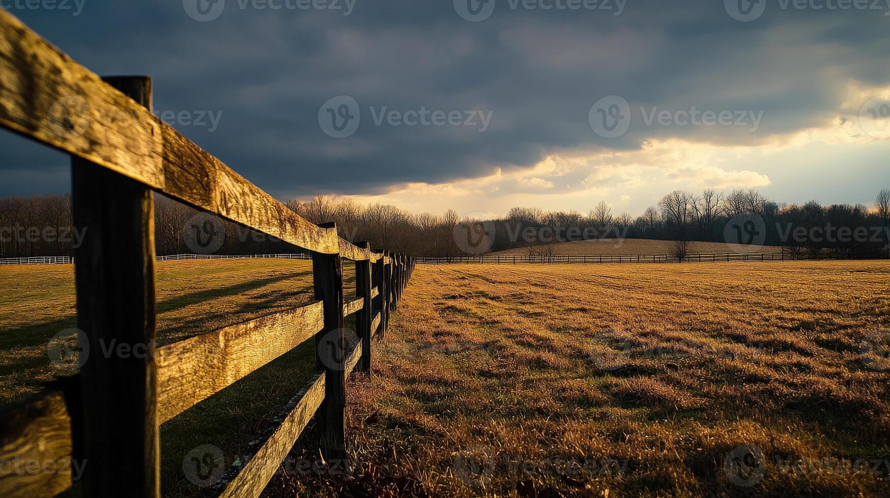 A wooden fence in a field with a stormy sky photo