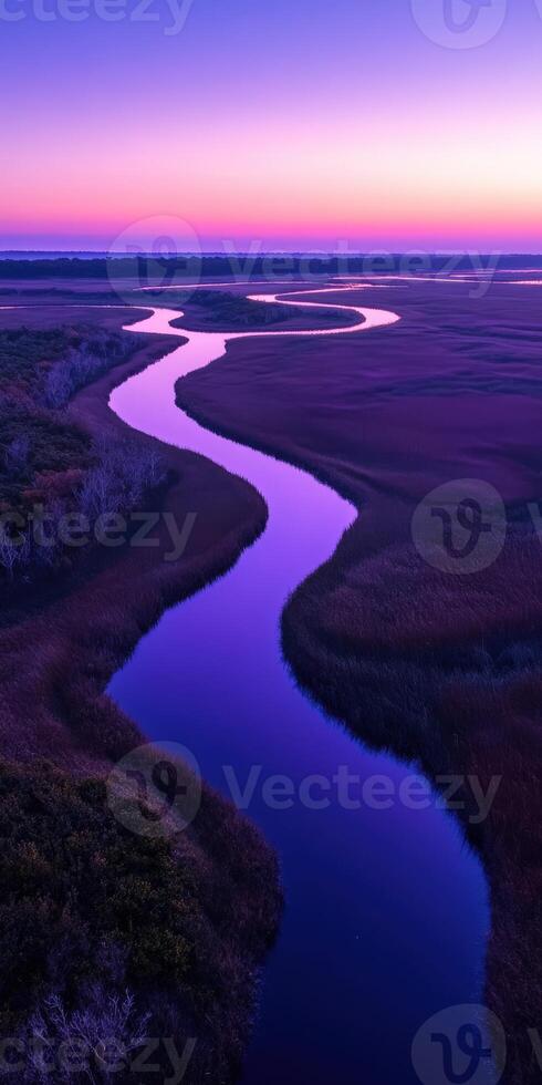 A river runs through a marsh at sunset photo