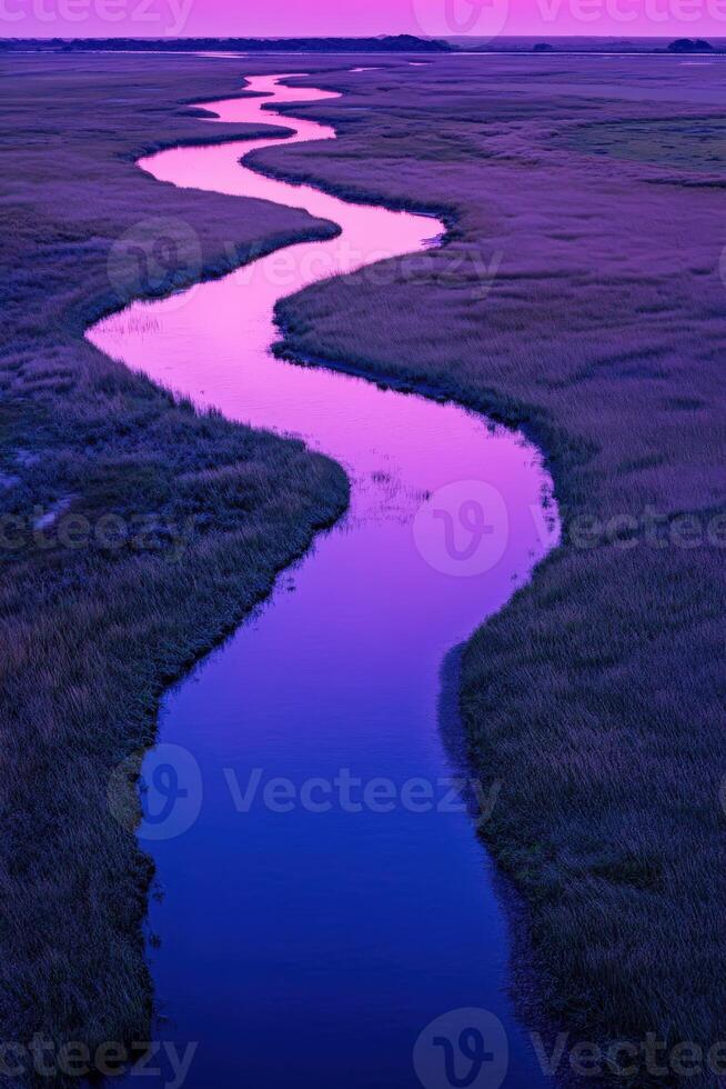 A river runs through a marsh at sunset photo