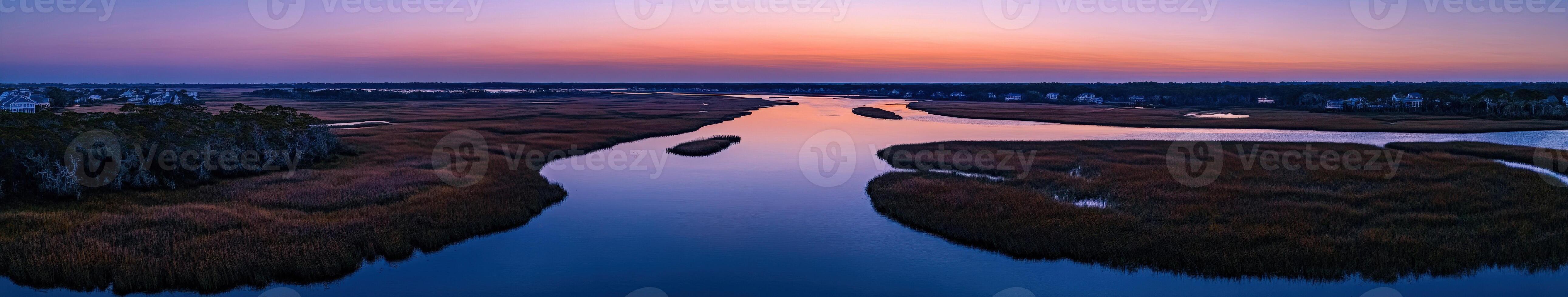 A river runs through a marsh at sunset photo
